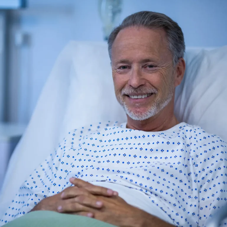 Portrait of sick patient sitting on bed at hospital